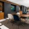 a room with tables, chairs and a tv
